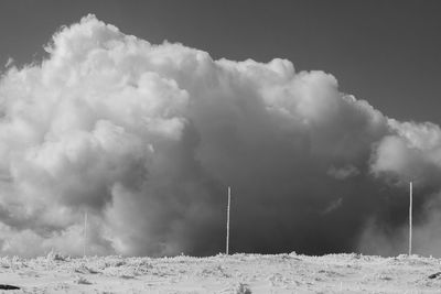 Smoke emitting from snow covered land against sky