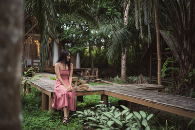Woman sitting on boardwalk in forest