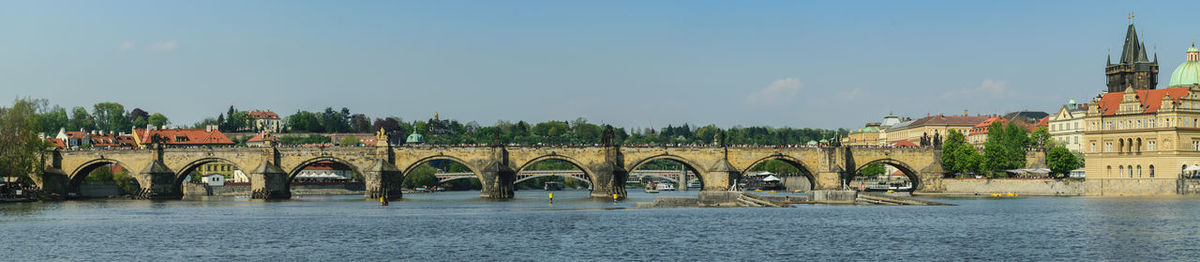 Arch bridge over river against buildings in city