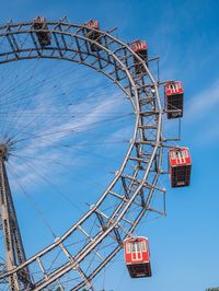 Low angle view of ferris wheel against blue sky