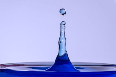 Close-up of water splashing against blue background