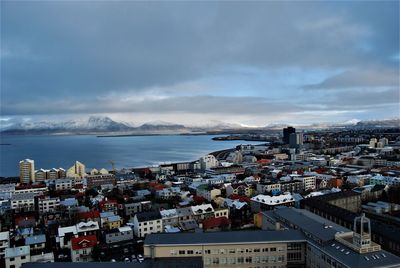 High angle view of cityscape by sea against sky