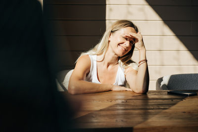 Portrait of young woman sitting on table