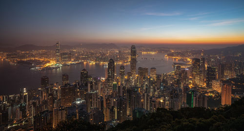 Illuminated cityscape against sky at night