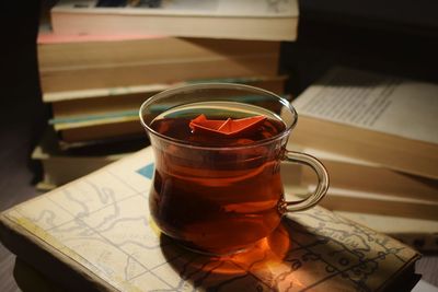 Close-up of paper boat on tea in glass on table