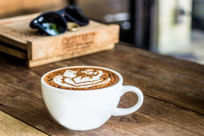 Close-up of coffee cup on wooden table