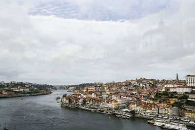 River amidst buildings in city against sky