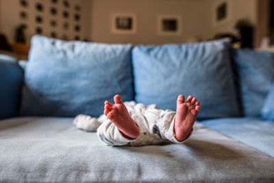 Close up of newborn's feet while stretching on the couch