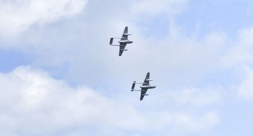 Low angle view of airplanes flying against sky