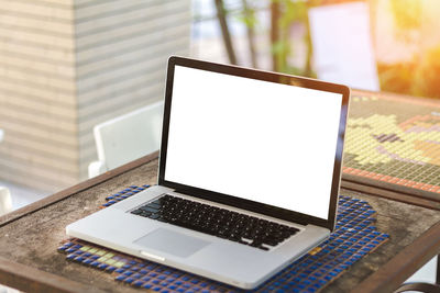 High angle view of laptop with blank screen at sidewalk cafe