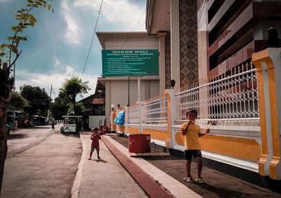 Rear view of people walking on street in city