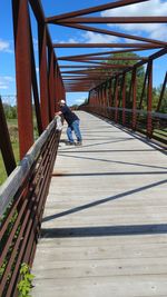 Side view of mature man leaning on bridge railing