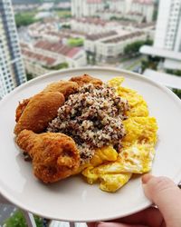 Close-up of hand holding food in plate