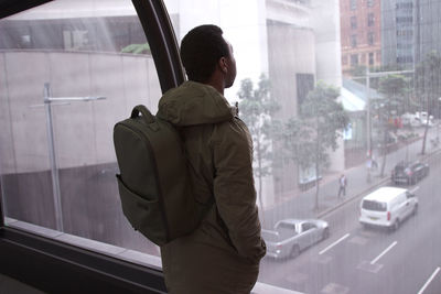 Man standing by window in city