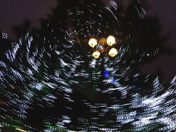 Close-up of water drops against illuminated sky at night