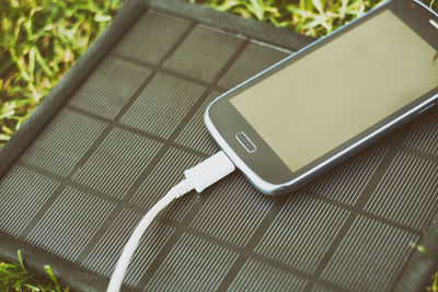 Close-up of mobile phone and solar charger