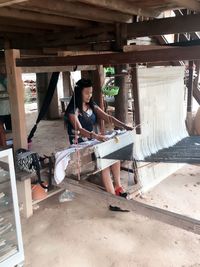 Woman weaving loom in factory