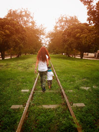 Rear view of woman walking on field