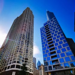 Low angle view of modern buildings against blue sky