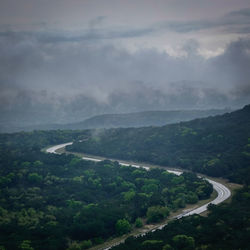 High angle view of road amidst landscape against cloudy sky at dusk