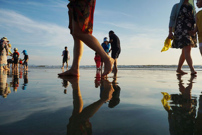 People at beach against sky