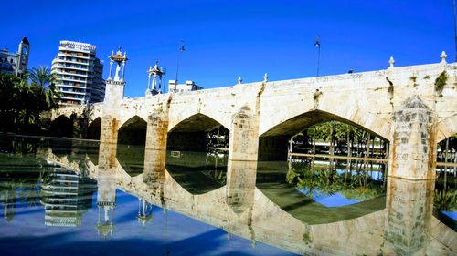 Arch bridge over canal against buildings