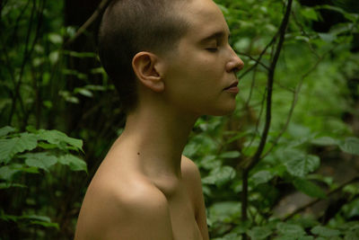 Portrait of shirtless man in forest