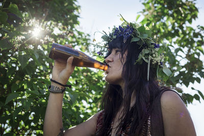 Woman wearing flower wreath drinking beet