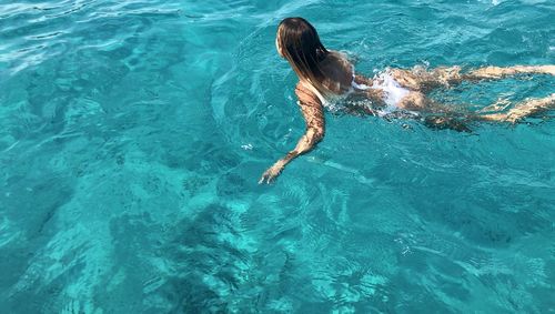 Rear view of woman swimming in pool