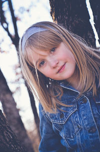 Close-up portrait of cute smiling girl with blond hair