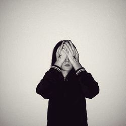 Low angle view of boy standing against wall