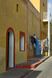 Clothes drying on alley amidst buildings