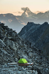 Scenic view of mountain against sky with tent in foreground 