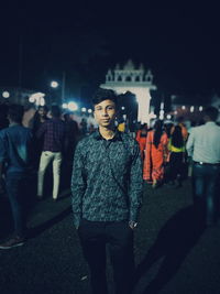 Portrait of young man standing city at night