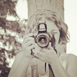 Cropped image of woman holding camera