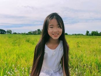 Portrait of smiling woman standing on field