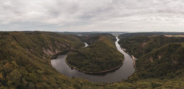 Panoramic shot of river amidst landscape against sky