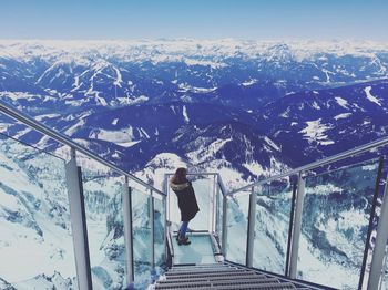 Woman on snowcapped mountain against sky