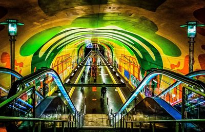 Multi colored illuminated staircase in building at night