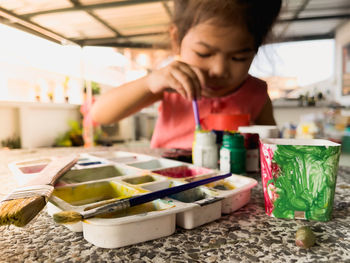 Girl holding ice cream on table