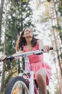 Side view of young woman riding bicycle