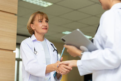 Portrait of smiling female doctor examining patient in hospital