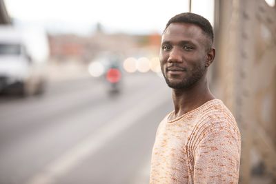 Portrait of young man standing on road