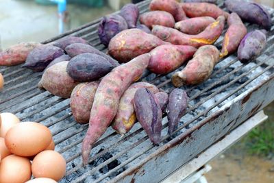 Close-up of sweet potatoes and eggs on barbecue grill