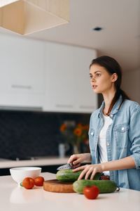 Portrait of young woman holding food at home