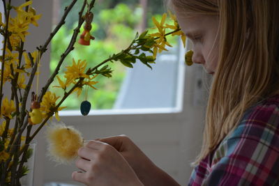 Cute girl looking at plants in home