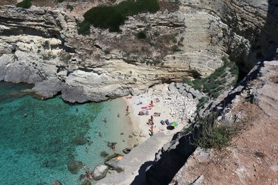 High angle view of people on rocks at shore