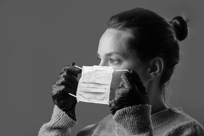 Portrait of young woman holding paper against white background