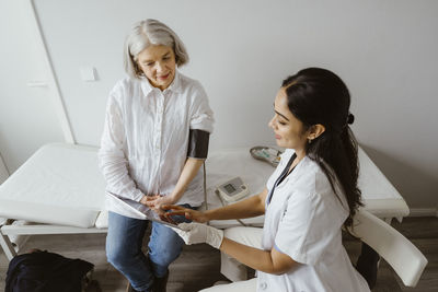 Doctor discussing with senior patient over tablet pc at clinic