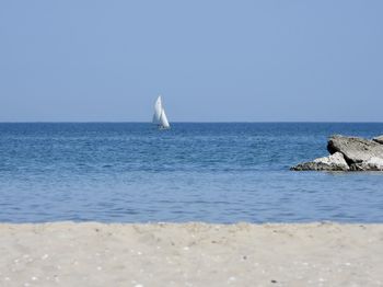 Sailboat on sea against clear sky